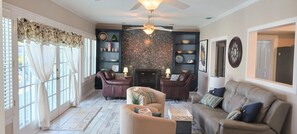 Cozy living room with a fireplace, comfortable seating, and artwork adorns the walls.