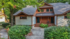 A two-story house with a front porch, a covered entryway, and a small front yard with shrubs. - 376 Disciples Village | Game Room | Fireplace | Walking Distance to Slopes! (Boyne Falls)