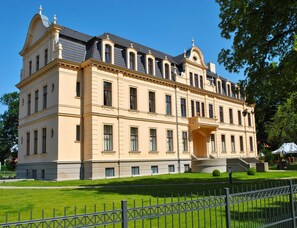 A large, historic building with a symmetrical facade, multiple windows, and a central entrance with steps. - Chalet in Wendorf (Kuhlen-Wendorf)