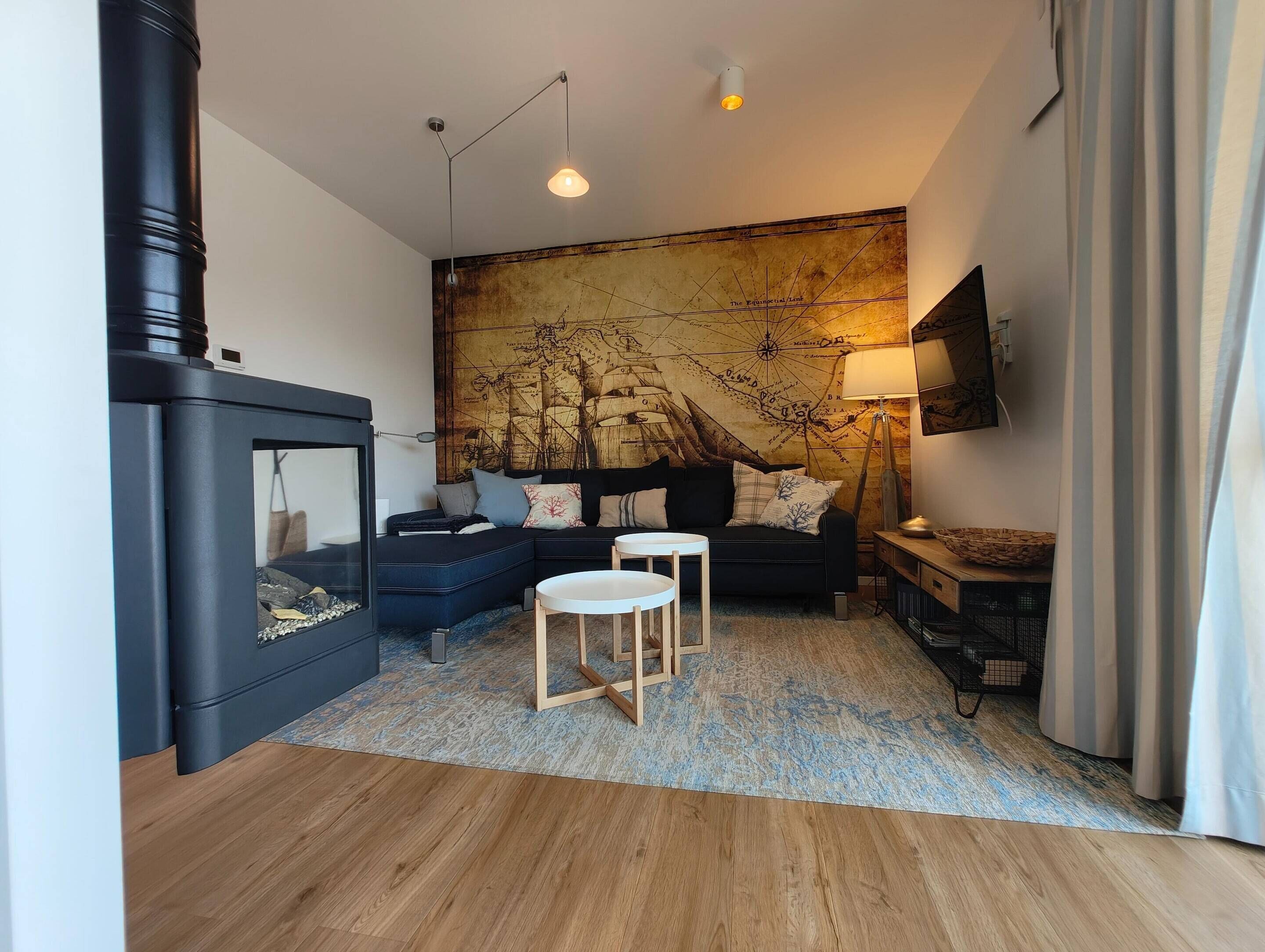 Una sala de estar moderna con un sofá modular, una chimenea, un mural de mapa y un televisor de pantalla plana.