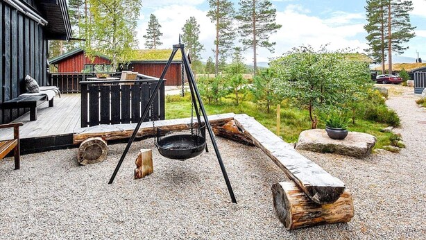 A wooden deck with outdoor seating, a swing, and a fire pit. - 5 Star Holiday Home in Treungen (Nissedal)