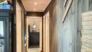A narrow hallway with wooden walls and a carpeted floor. A wooden sign with text is visible on the right wall. - 5 Star Holiday Home in Treungen (Nissedal)