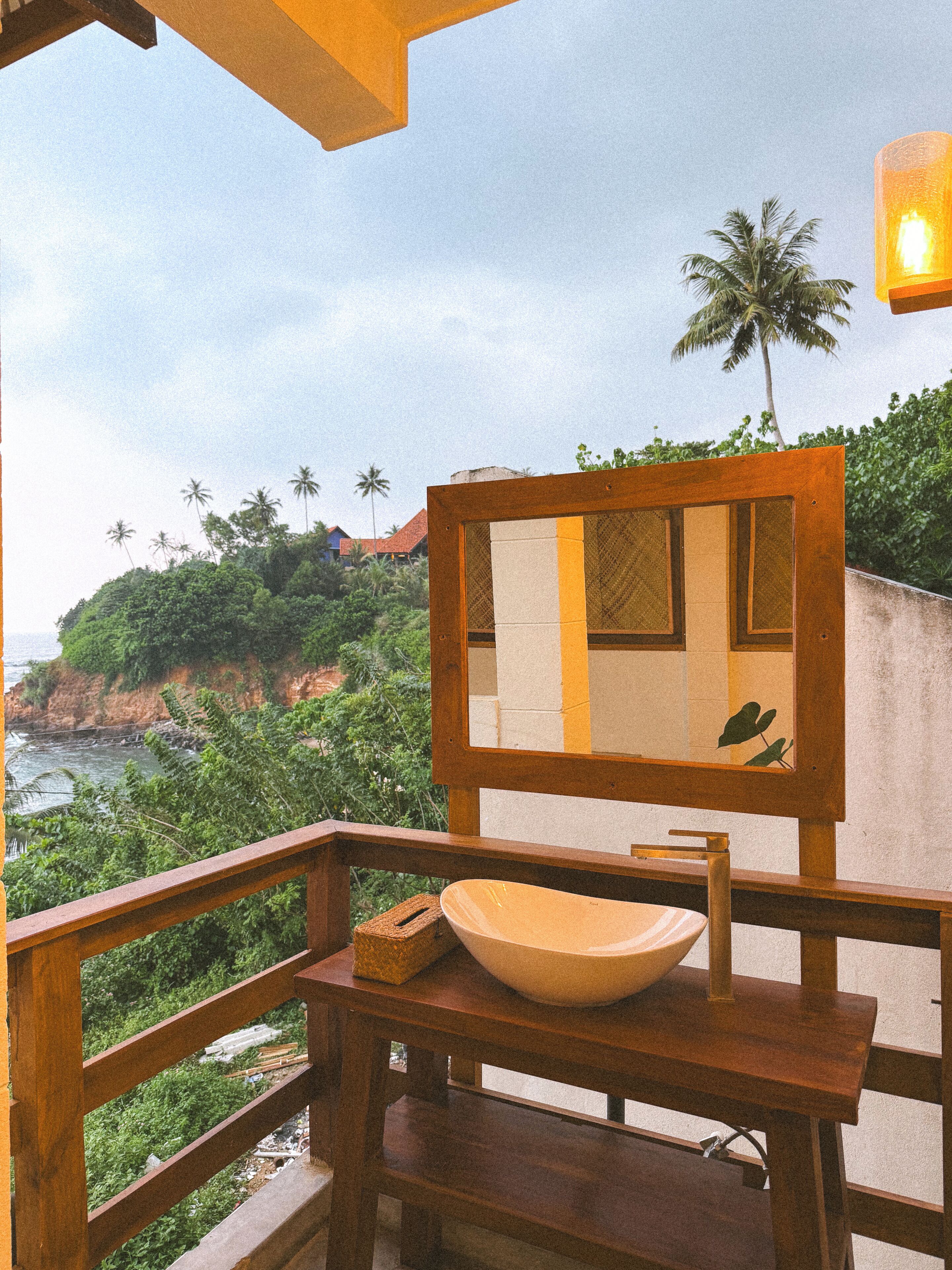 A wooden deck with a stone sink and a mirror.