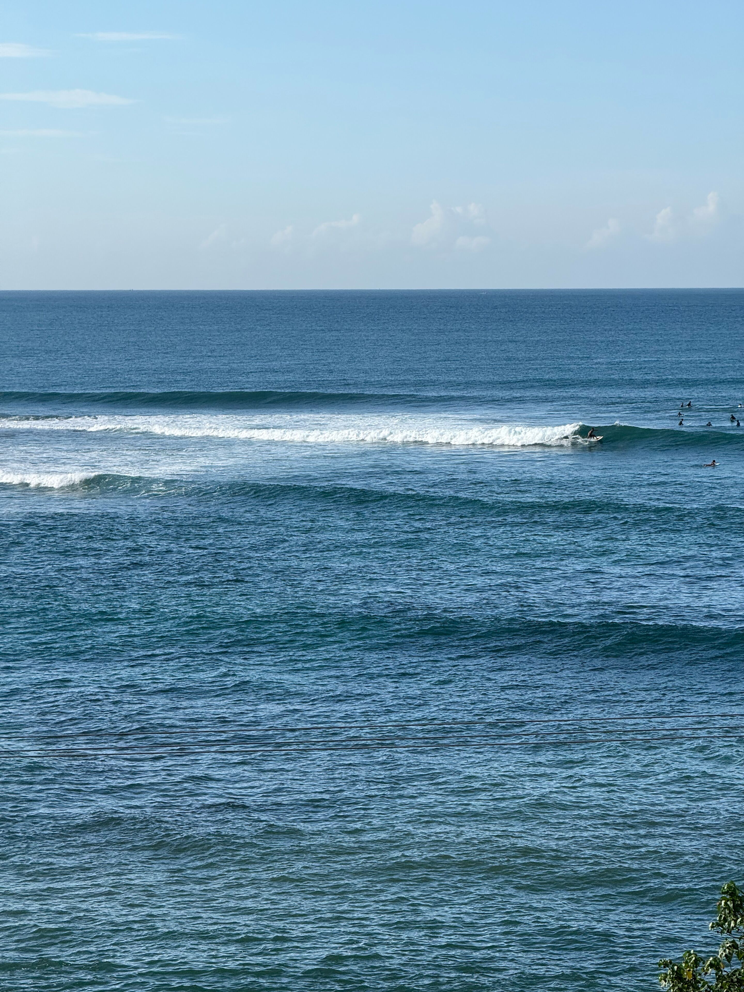A coastal view with waves and surfers.