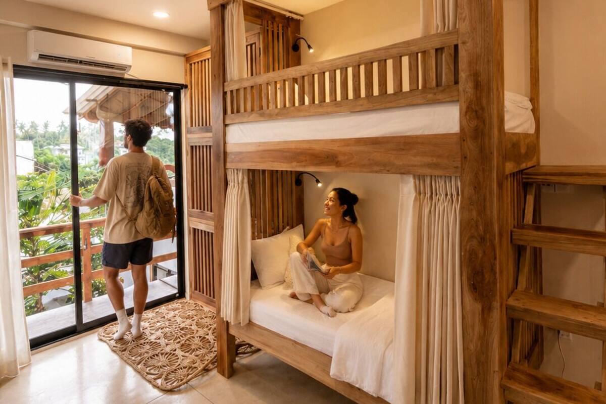 Un lit superposé avec une structure en bois, une porte-fenêtre coulissante donnant sur un balcon et un petit tapis sur le sol.