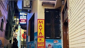 A narrow alley with a building featuring a sign for 'Maya Inn Guest House' offering AC and non-AC rooms, WiFi, and boat service. - Maya Inn Paying Guest House By GRB (Varanasi)
