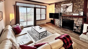 A living room with a fireplace, a sofa, a coffee table, and a television.
