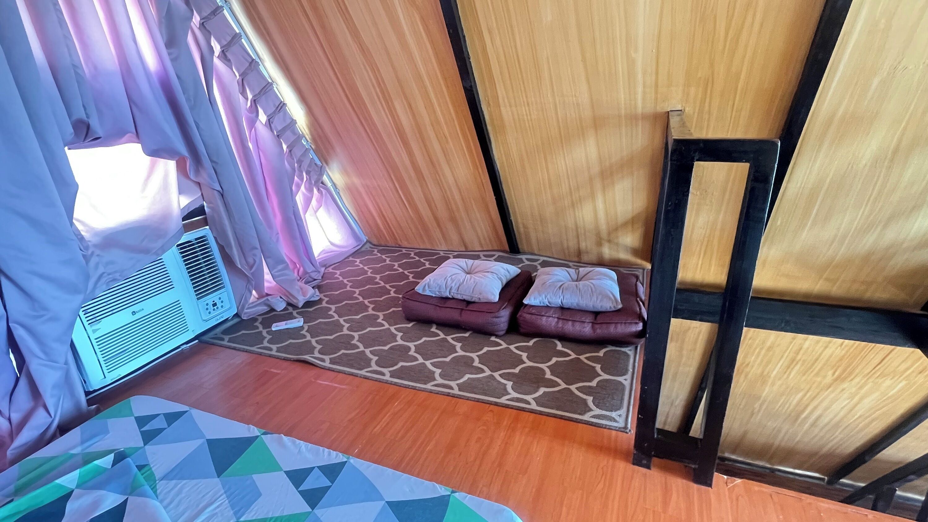 Une pièce comprenant un lit, un radiateur, un tapis et une petite table.