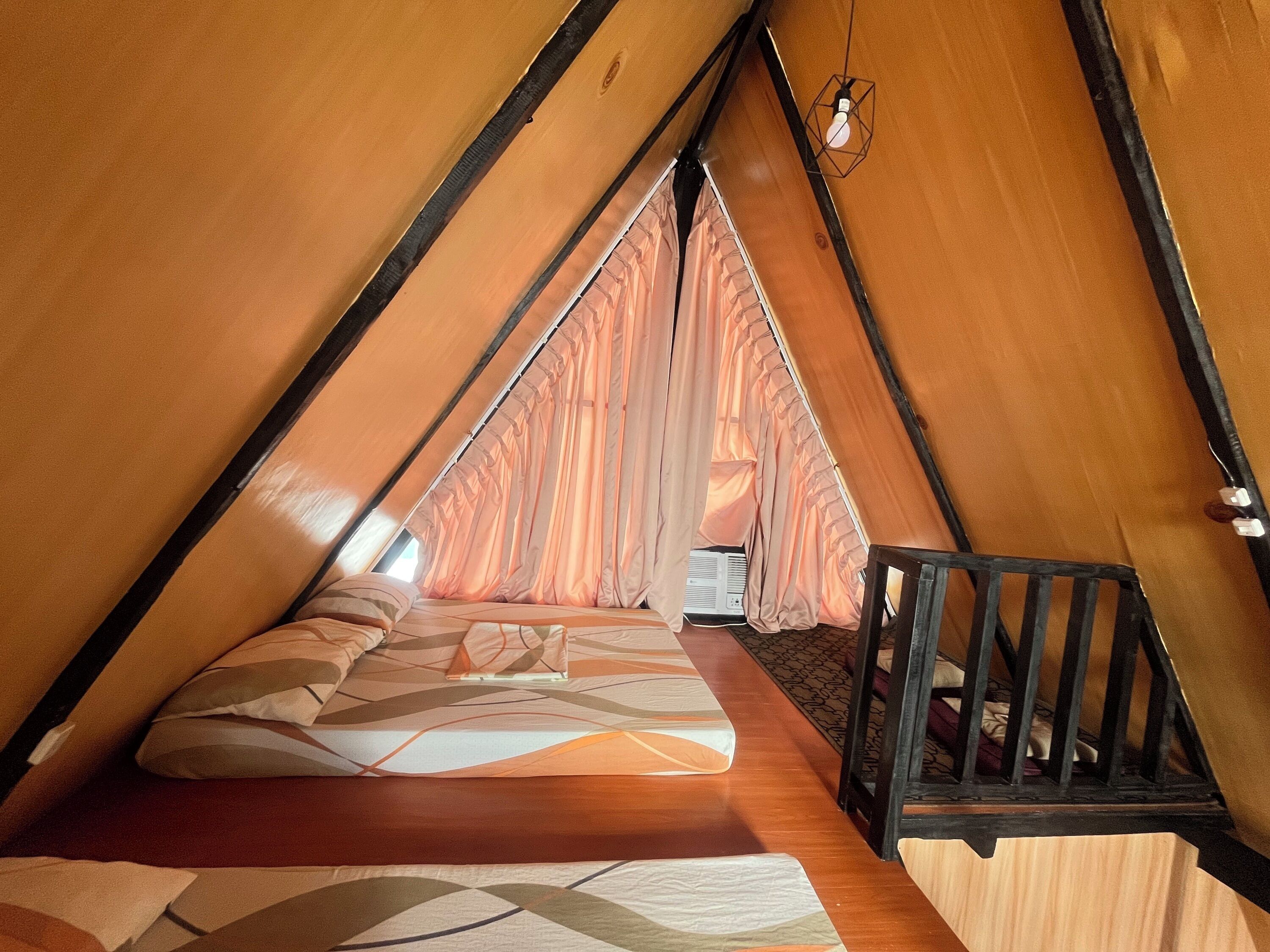 Un rincón acogedor, triangular, con una cama, una mesita y una silla.