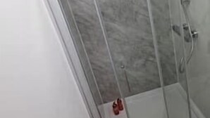 A glass-enclosed shower area with a marble floor and a white door. - FC Platinum Accommodation (Watford)