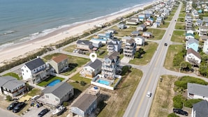 Zona residencial costera con casas, una playa y una carretera.