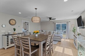A modern kitchen with a dining area, wooden furniture, and a ceiling fan. - Field of Dreams #177 - 3BD Beach Cottage, Steps from the Ocean! (North Topsail Beach)