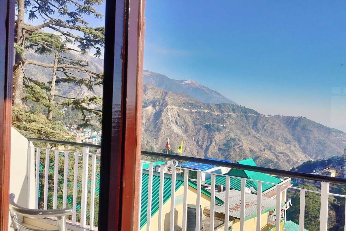 A balcony with a view of mountains and buildings.