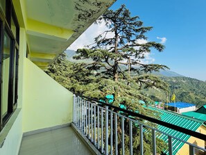 Un balcon avec vue sur une montagne et un arbre.