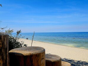 Guests can walk along the sandy beach, enjoying the ocean views.