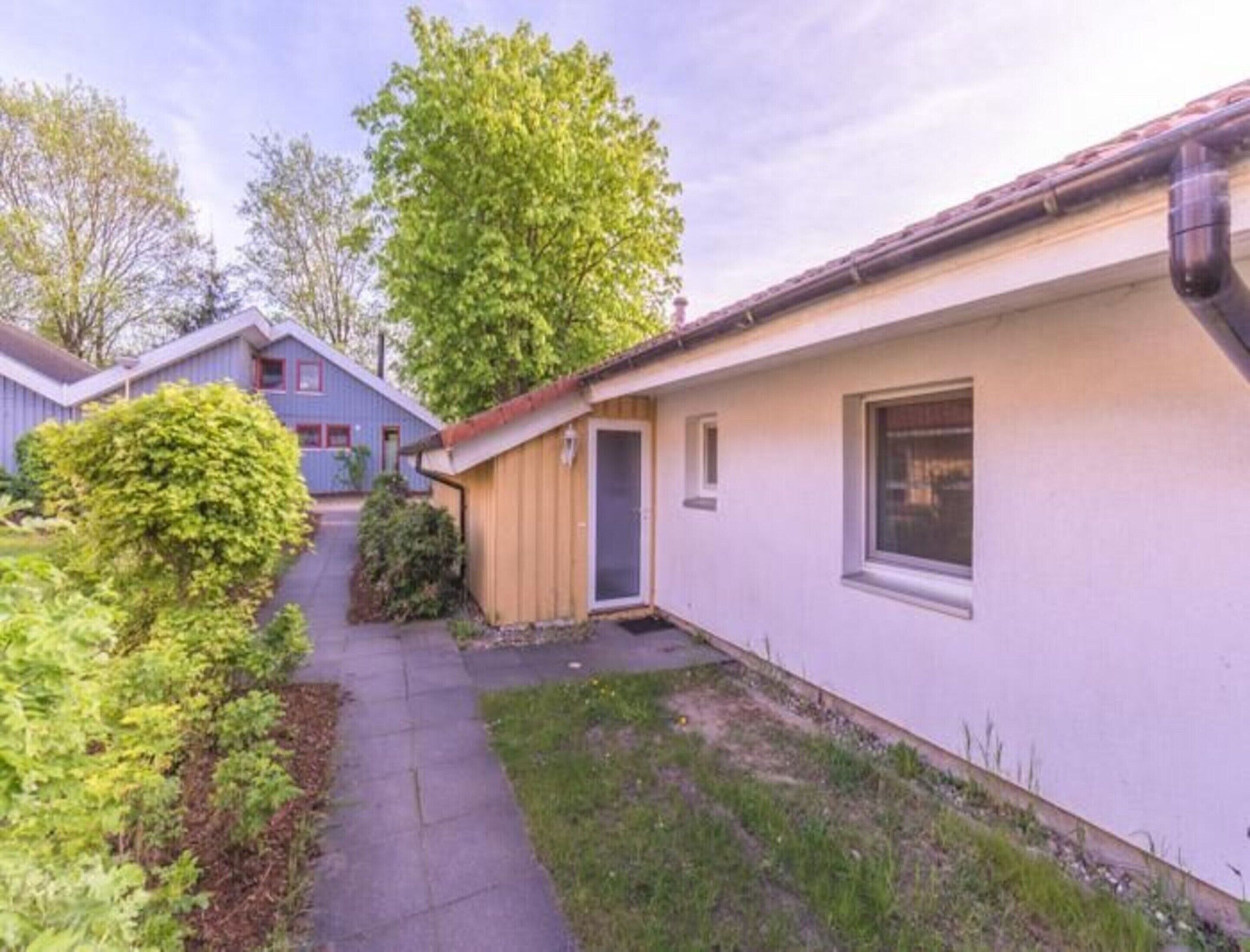 A single-story building with a small porch and a door leading to a garage.