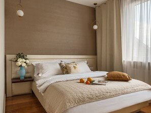 Une chambre à coucher avec un lit, une table de chevet, une lampe, des rideaux et une fenêtre.