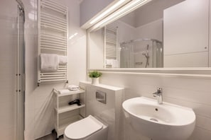 Ein modernes Badezimmer mit Toilette, Waschbecken und Dusche.