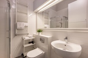 Une salle de bain moderne équipée de toilettes, d’un lavabo et d’une douche.