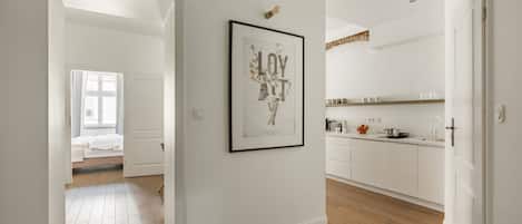 A modern interior with a hallway leading to a bedroom and a kitchen area.