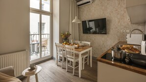 Een moderne keuken met een eethoek, een groot raam en een flatscreen televisie.