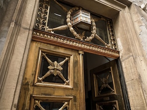 An ornate entrance with a decorative window and a sign above it.