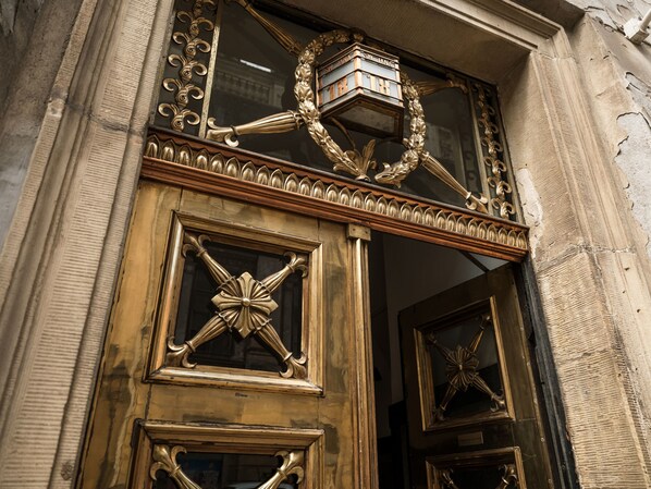 Una entrada ornamentada con un ventanal decorativo y un cartel arriba.