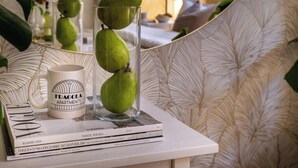 A table with a mug, a glass with pears, and books.