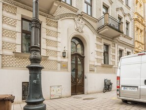 A building with a prominent entrance, a metal pole, and a parked van.