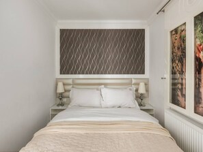 Ein Schlafzimmer mit einem Bett, zwei Nachttischen, einem Kopfteil und einem Fenster mit Blick.