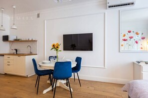 A modern kitchen with white cabinets, a wooden countertop, and a built-in oven. - Poppy studio with balcony (Kraków)