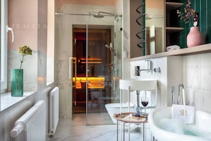 Ein modernes Badezimmer mit einer Duschkabine aus Glas, einem weißen Waschbecken und einem Marmorboden.