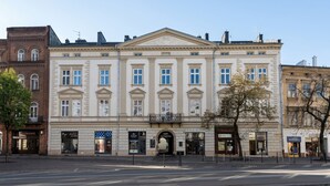 A historic building with a central entrance, multiple windows, and a flat facade. - Blue Suede apartment (Kraków – Old Town)