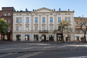 A historic building with a central entrance, multiple windows, and a flat facade.