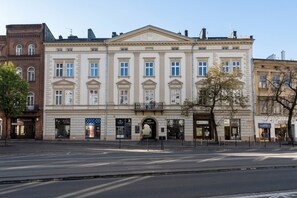 Ein historisches Gebäude mit einem zentralen Eingang, mehreren Fenstern und einer flachen Fassade.