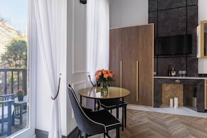 A modern kitchen with a built-in oven, a dining area with a round table and chairs, and a view of the outdoors.