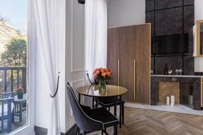 Een moderne keuken met een ingebouwde oven, een eethoek met een ronde tafel en stoelen, en uitzicht op de omgeving.