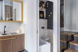 Un baño moderno con inodoro, lavamanos y zona de ducha.