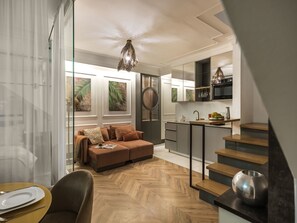 A modern interior with a sofa, dining table, and kitchen area.