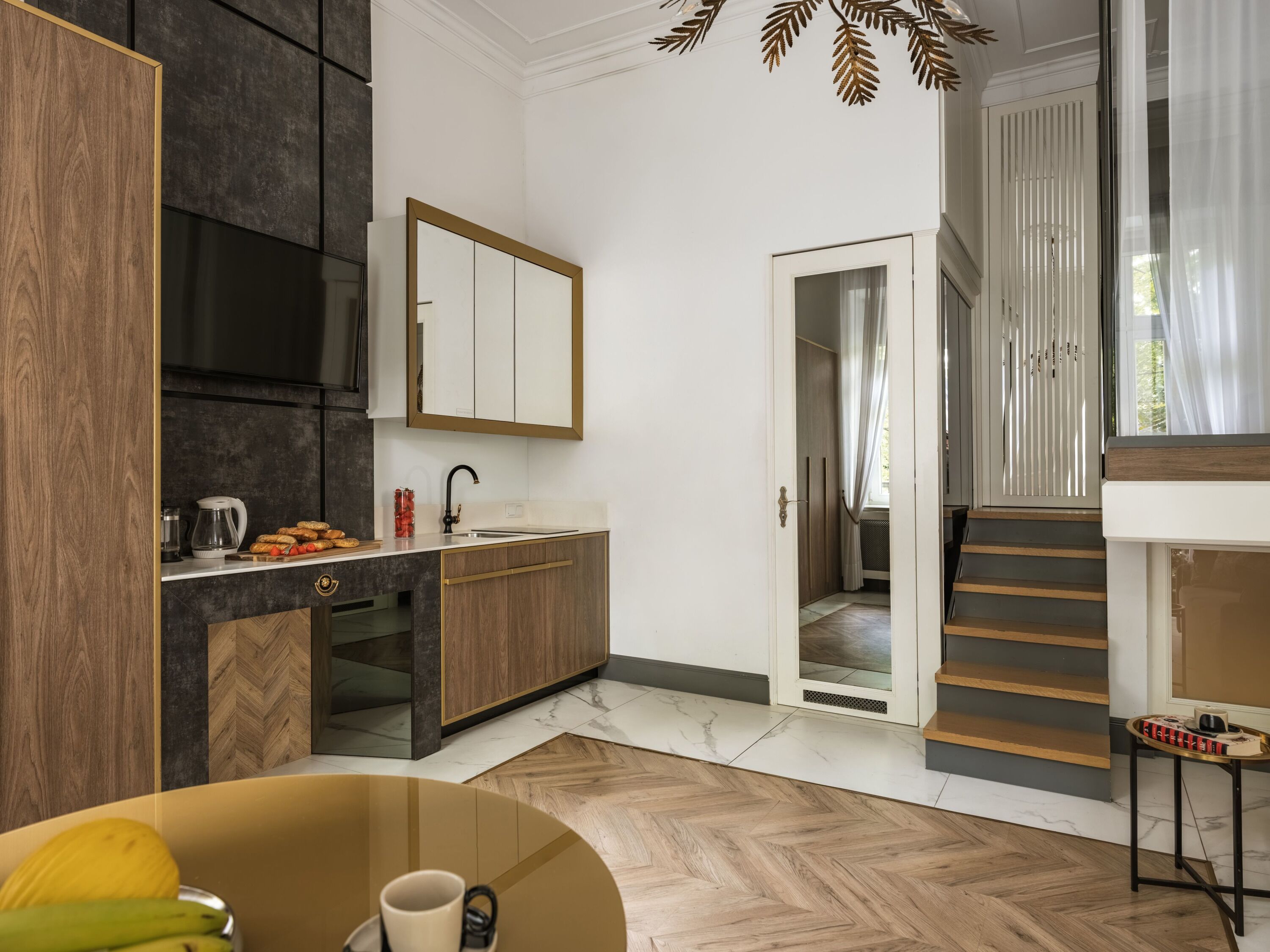 Eine moderne Küche mit Backofen, Spüle und einer Arbeitsplatte mit Kaffeemaschine und Snacks.