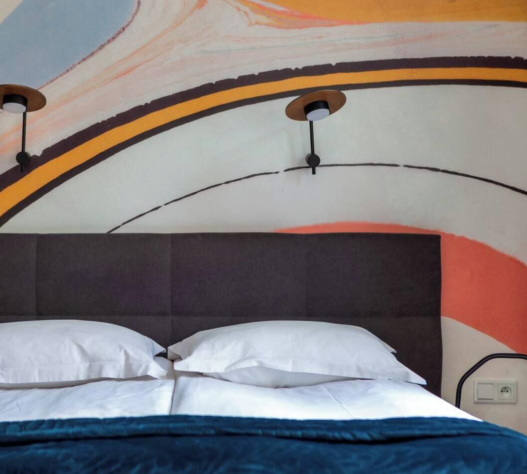 A bed with a headboard, pillows, and a blanket.