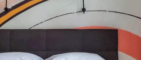 A bed with a headboard, pillows, and a blanket.