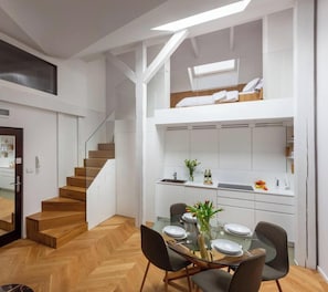 Un interior moderno con comedor, cocina y escalera.