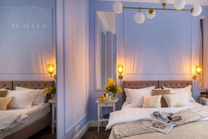 A bedroom with a large bed, two bedside tables, a mirror, and a chandelier. - Apartment Lavender - One Bedroom Apartment, Sleeps 4 (Kraków – Old Town)