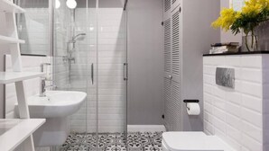 A modern bathroom with a glass-enclosed shower, a white sink, and a toilet. - Apartment Lavender - One Bedroom Apartment, Sleeps 4 (Kraków – Old Town)