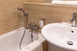 Une salle de bain avec une baignoire, un lavabo et une serviette.
