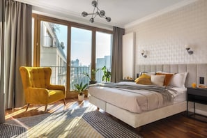 A modern bedroom with a large bed, a yellow armchair, a view of the city, and a balcony. - Sunny studio with balcony (Kraków – Old Town)