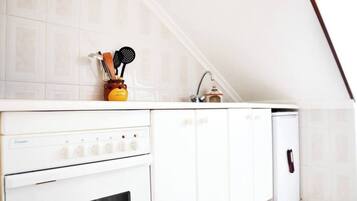 A kitchen with white cabinets, a stove, and a sink.
