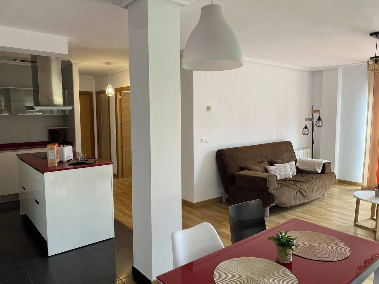 A modern living space with a kitchen, dining area, and a sofa.