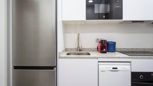 Une cuisine moderne équipée d’appareils électroménagers en acier inoxydable, d’un four à micro-ondes et d’un lave-vaisselle.